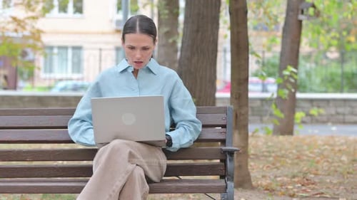 Young Woman Shocked by Loss on Laptop Outdoor