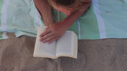 Man Reading a Book on the Beach Tourist Enjoy a Delightful Escape While Relaxing on the Beach with a