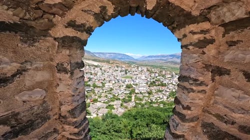 Panning between the city and a window to the Ottoman castle fortress of Gjirokaster or Gjirokastra.