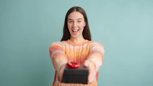 Woman Presents Gift with Smiling, Expressive Joy