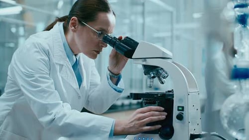 Female Scientist Uses Microscope in Modern Laboratory
