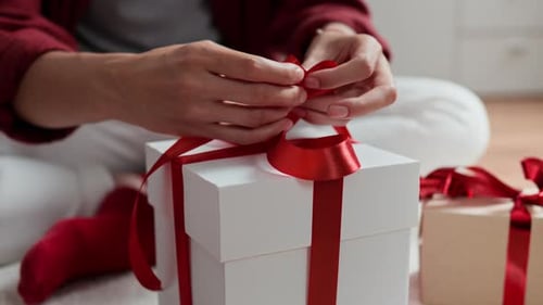 Tying a Red Ribbon on a Christmas Gift