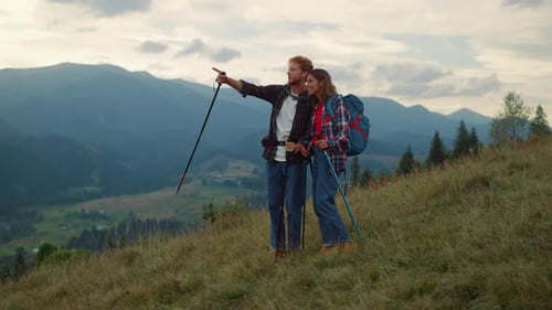 Couple Hiking on Mountain Top During Cloudy Day