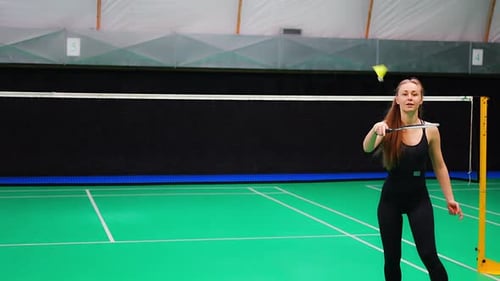Sports Young Woman with Racket and Shuttlecock is Exercising Doing Warmup Before Playing in