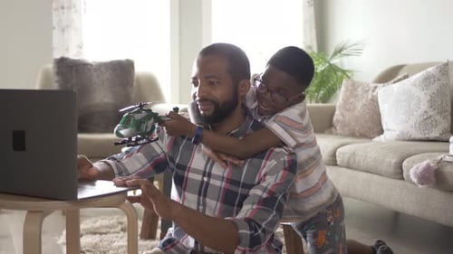 Father and Son Working and Playing in Living Room Adult