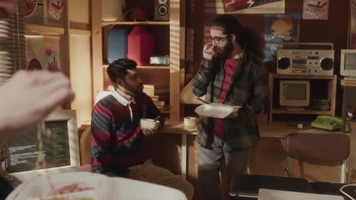 Geeks Chatting while Having Lunch Together at Home Office