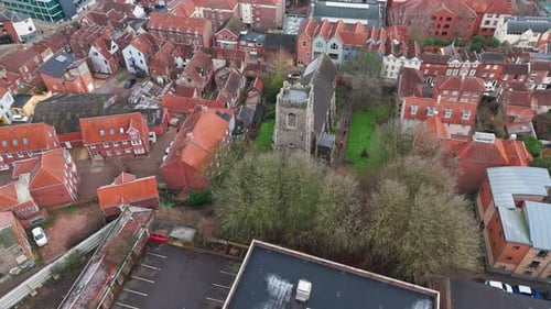 Aerial view of Norwich showcasing historic church, turreted roofs, and surrounding shops