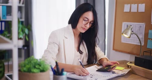 Businesswoman Uses a Calculator Analyzes the Company's Financial Report She Is SelfConfident