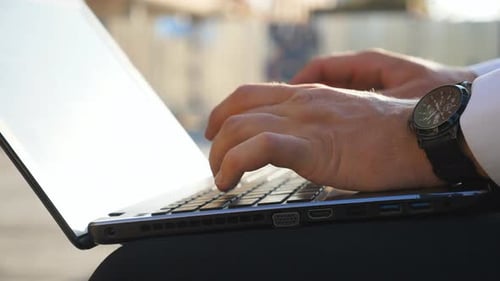 Close Up to Male Hands of Successful Businessman Typing Text on Notebook Keyboard Outdoor Arms of