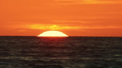 The Evening Sun Sets Above the Sea on the Horizon