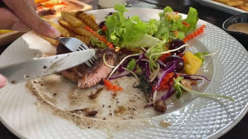 Cutting Steak with Knife on Plate