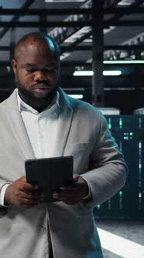 Vertical Video Data Center Engineer Monitoring Servers Performing AI Training