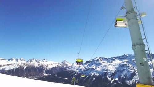 Skiers On Chair Lifts In Ski Resort