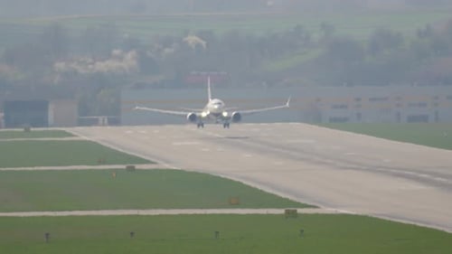 Airplane gracefully touches down on a tranquil runway in a beautiful setting