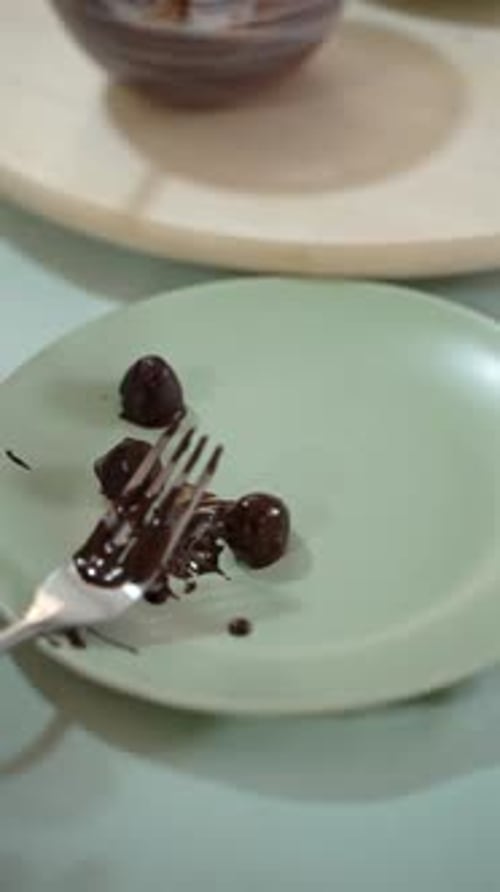 Dipping truffle candy and berries in chocolate close-up