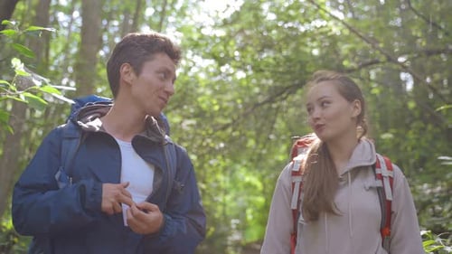 Young Couple Walks Together Discussing Things in Forest