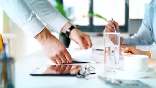 Businessman shows charts to businesswomen in corporate office setting