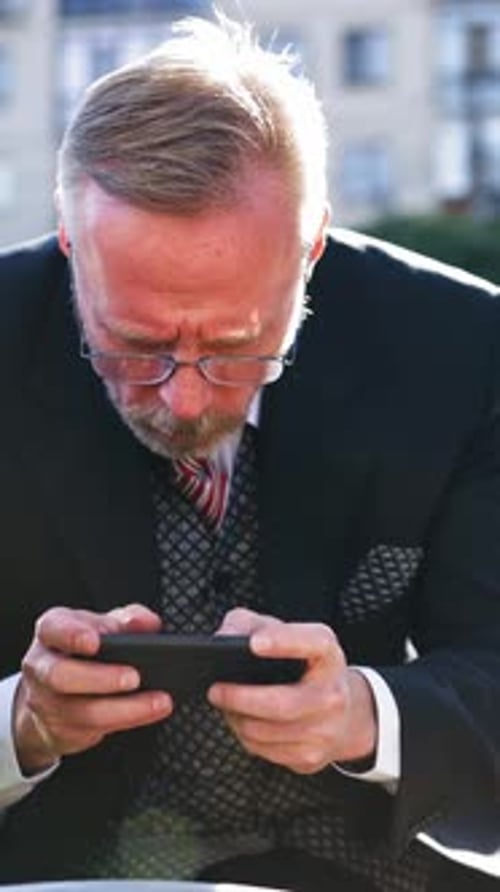 Man Using Smartphone Outdoors in Urban Setting