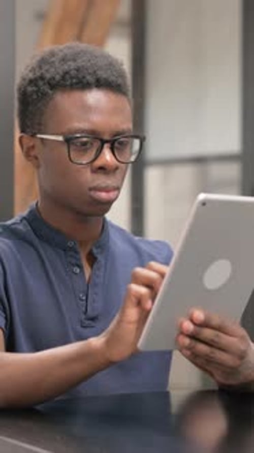 Young Man Using Tablet Device Indoors