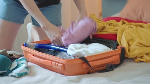 Woman Packing Clothes in Suitcase for Travel