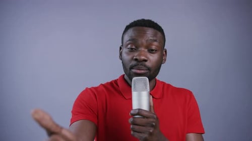 Man Speaks into Microphone with Hand Gestures