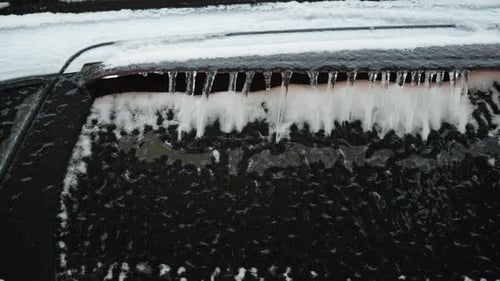 Icicles and Snow on Frozen Car in Winter