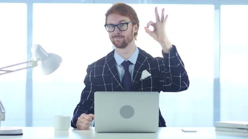 Man Gives OK Hand Gesture in Office Setting