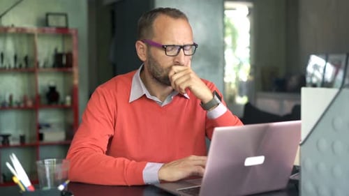 Man Looking Stressed at Computer in His Office