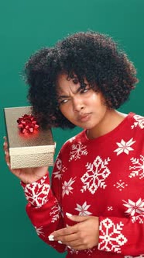 Christmas, shake present and face of woman in studio for holiday, giveaway and festive season