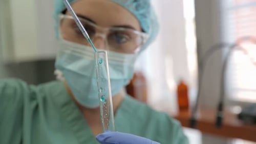Scientist Adding Liquid to Test Tube in Lab