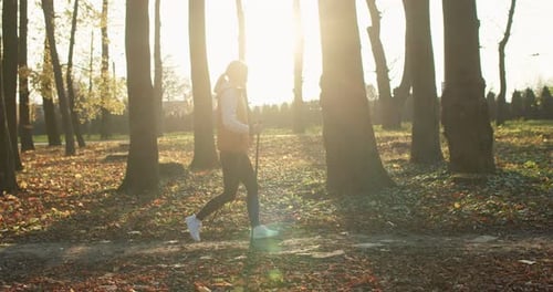 Side View Beautiful Healthy Active Cute Young Woman Walking Hiking with Nordic Walking Poles in