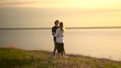 Romantic Couple Embracing at Sunset by the Lake