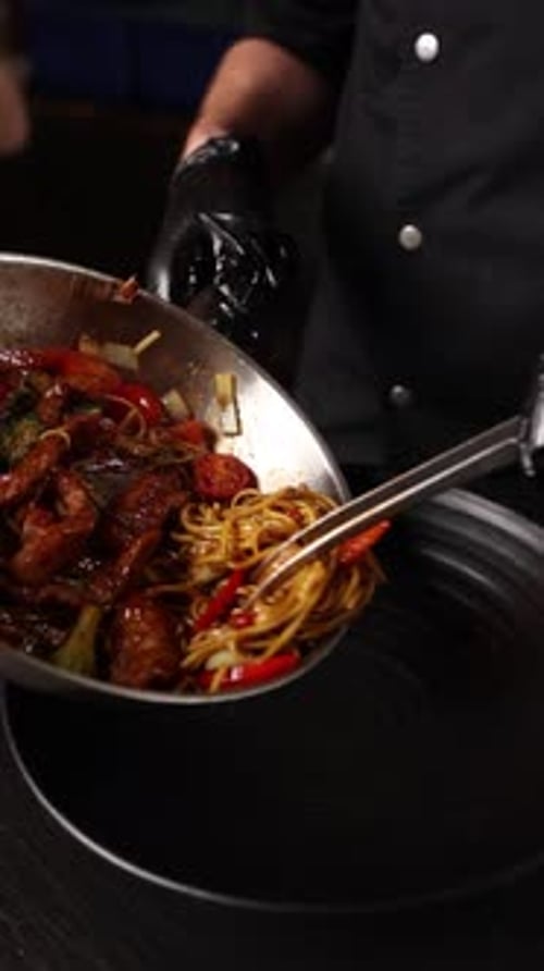 Chef Serving Noodles in Restaurant Kitchen