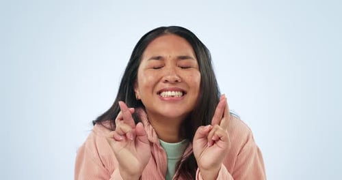 Fingers crossed, face and woman with hope in studio waiting for luck, results