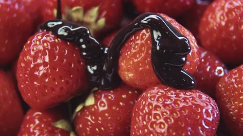 Chocolate Syrup Being Poured on Fresh Strawberries