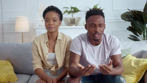Un homme et une femme sont assis ensemble sur un canapé en appréciant la conversation