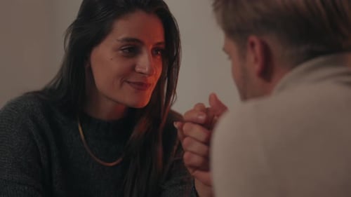 Woman Smiling at Man, Holding Hands Indoors