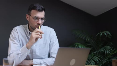 Mann schaut während des Arbeitstages auf den Computerbildschirm und sitzt am Tisch in der Klinik Spbi