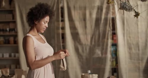 Contenido: Mujer empacando un producto ecológico por pedido