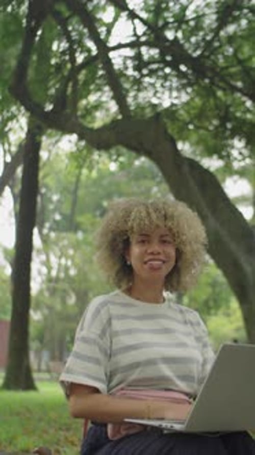 Portrait of Smiling College Girl with Laptop in Park