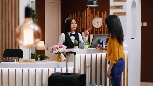 Hotel Receptionist Helping Customer with Luggage