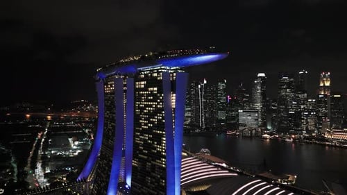 Spin around neon blue Marina Bay Sands at night, cloudy sky