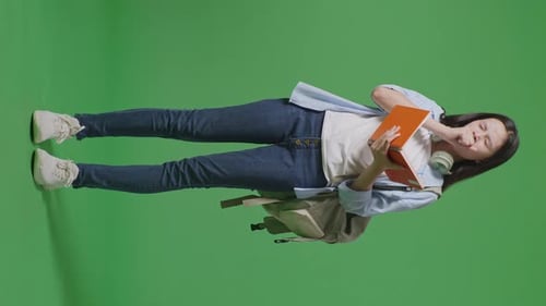 Full Body Of Asian Teen Girl Student Reading Book And Yawning In The Green Screen Background