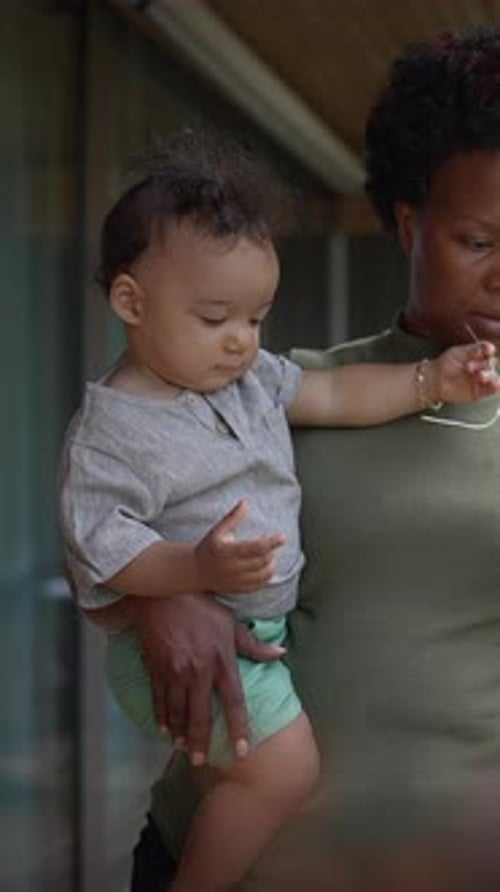 Mother Holds Infant Indoors During the Day