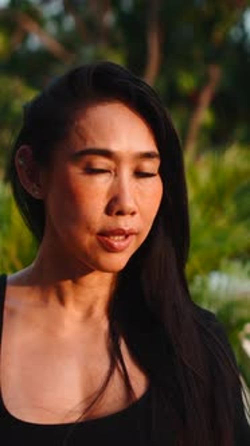 Smiling Woman Poses in Lush Green Outdoor Setting