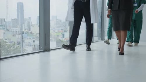 Unrecognizable Healthcare Workers Walking along Clinic Hall