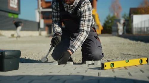 Construction Worker Building a Paved Road on Site