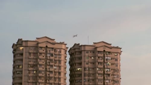 Airplane Flying Near Apartment Buildings in the City