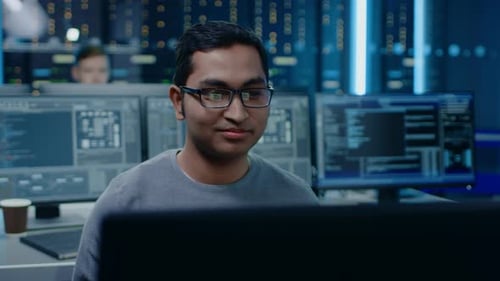 Man coding in blue lit data center