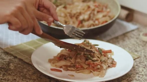 Preparing Noodles with Vegetables on Plate in Kitchen